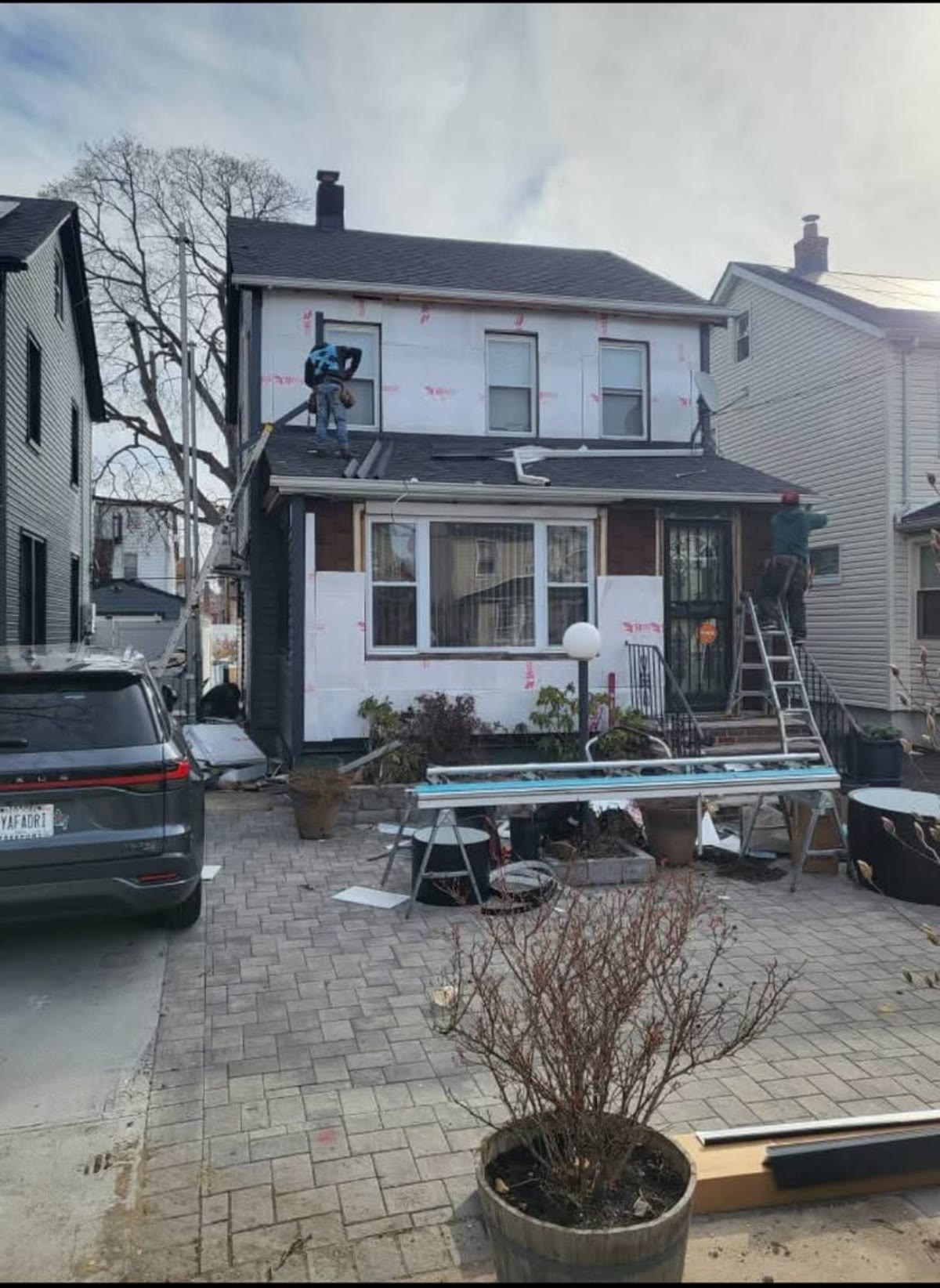House mid-project with old siding removed and house wrap exposed